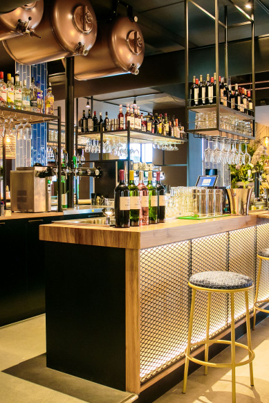 Man leest de krant aan de bar in Grand-Café Restaurant in Schagen.